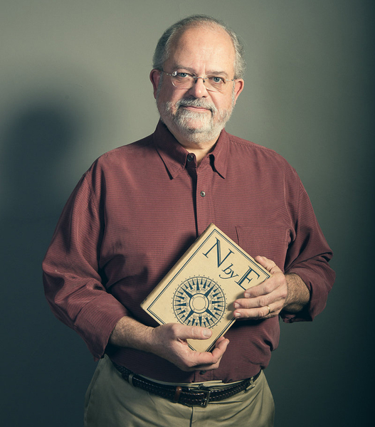 Portrait photo of Bob Smith holding a hardcover book featuring a compass rose and the title "N by E"