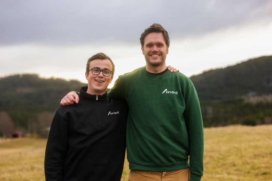 Øie Kolden and Lars Erik Fagernæs, both wearing Aviant shirts, pose together on a grassy field on a cloudy day.