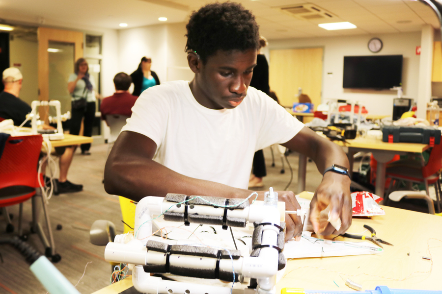 A student with a cochlear implant works on his ROV in a classroom
