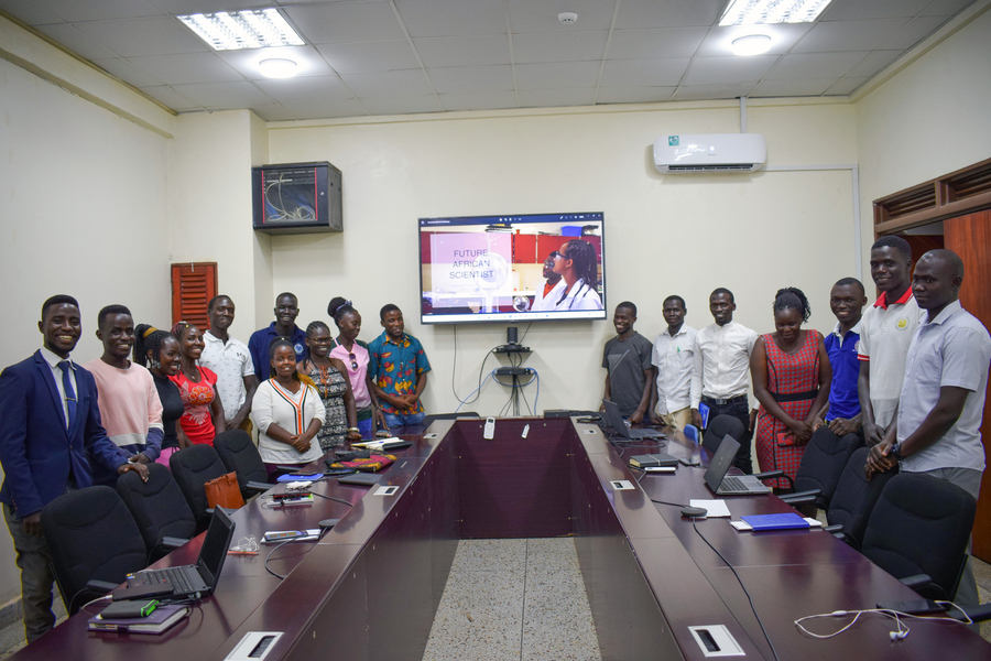 About 15 scientists pose for photo in a meeting room.
