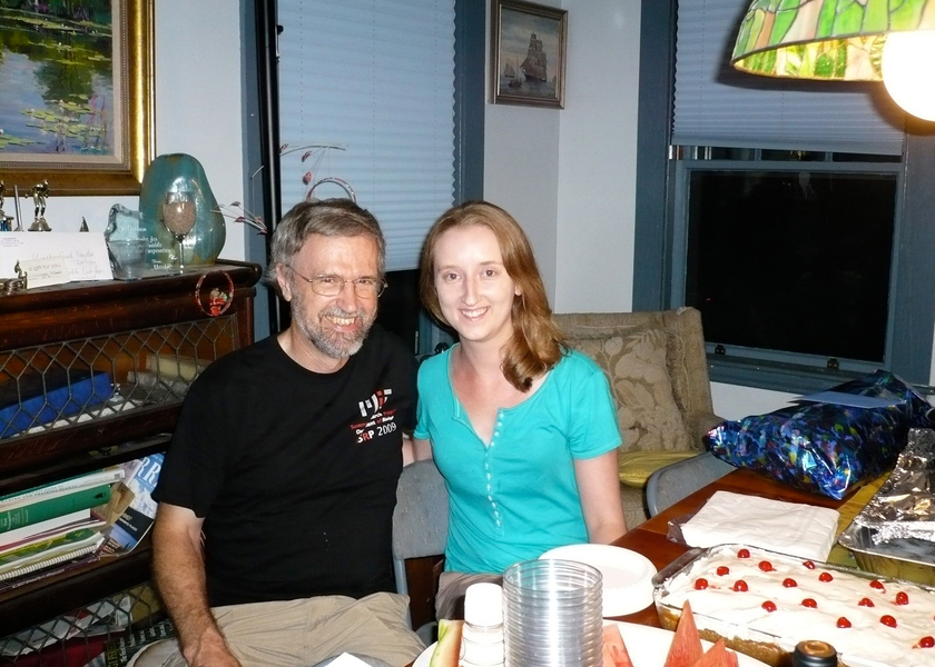 Graham Walker and Mary Ellen Wiltrout sit at a table that's covered in food in someone’s home