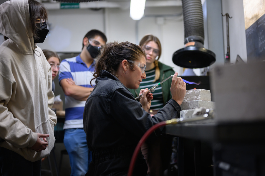Rhea Vedro demonstrates the use of a torch to a group of students