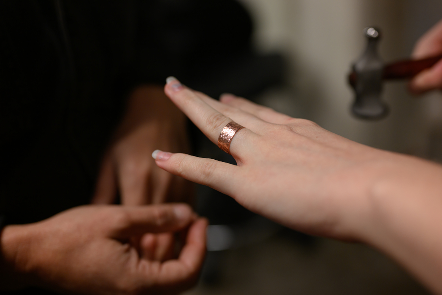 Closeup of a metal ring on a student's finger.