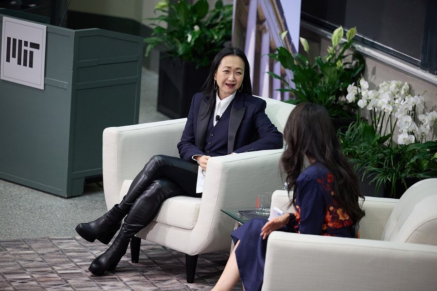 Two women speak to each other sitting in chairs.