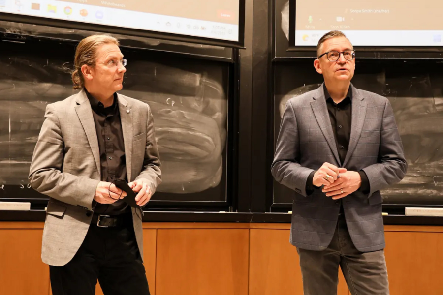 Zoltan Spakovsky and Olivier de Weck discuss the program in front of a classroom, with a blackboard behind them.