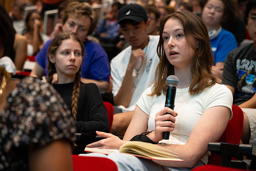 Lauren Watabe, seated in a classroom, speaks into a microphone