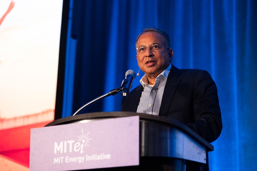 Praveer Sinha speaks at a lectern with the MITEI logo