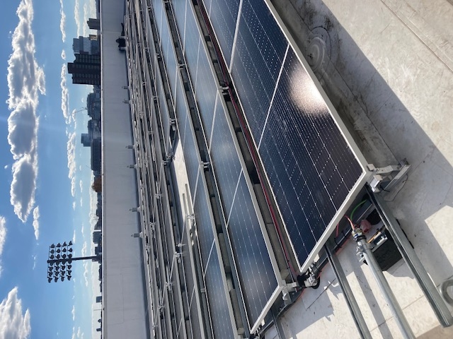 Solar panels on a roof against a city skyline