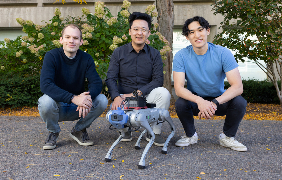 Alan Yu, Phillip Isola, and Ge Yang squat behind a small silver quadruped robot