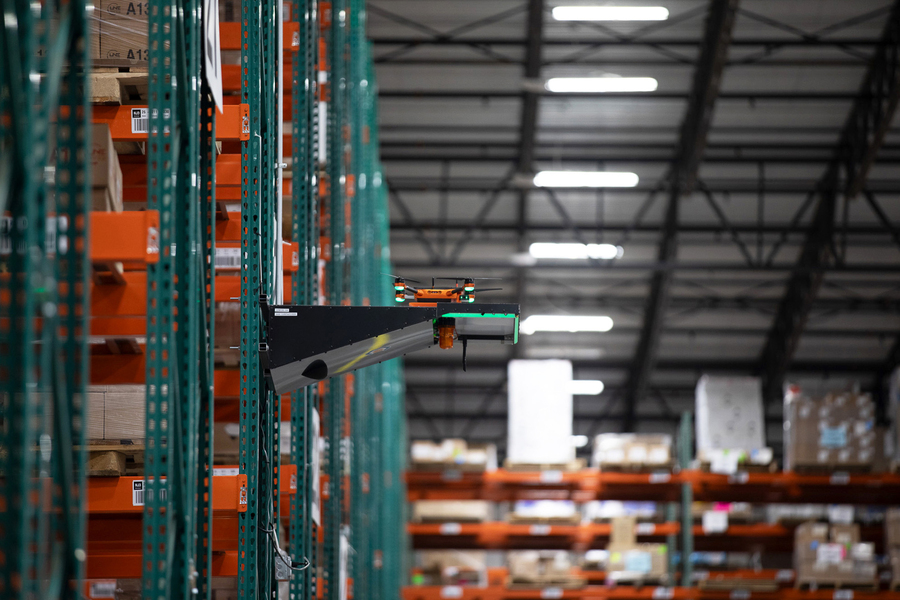 A drone sitting on a small platform in a warehouse