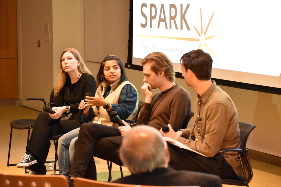 Chhavi Sood, Lace Riggs, Lukas Vogelsang, and Micheael Segel sit in a line of chairs on a stage