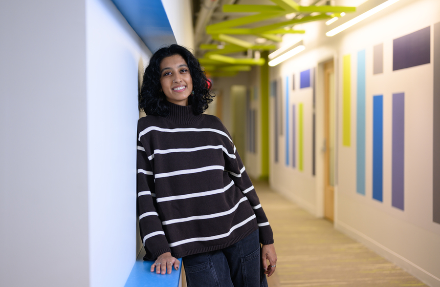 Portrait of Shreyaa Raghavan leaning against a wall in a hallway