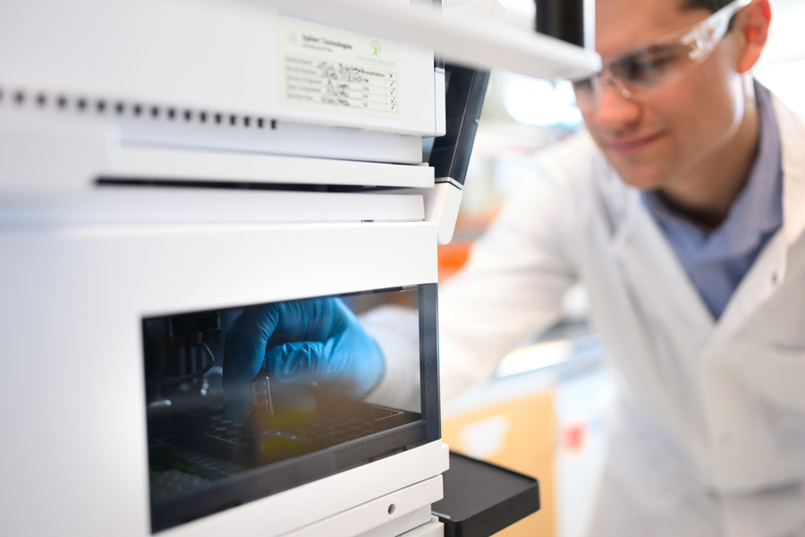  A gloved hand inserting a device into a machine 