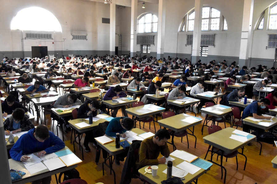 Hundreds of students at identical desks, heads down while taking the Putnam exam.