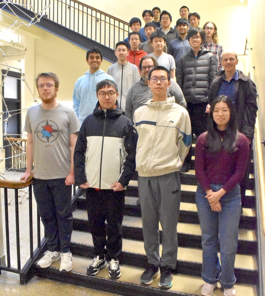 About 20 students and professors standing along staircase
