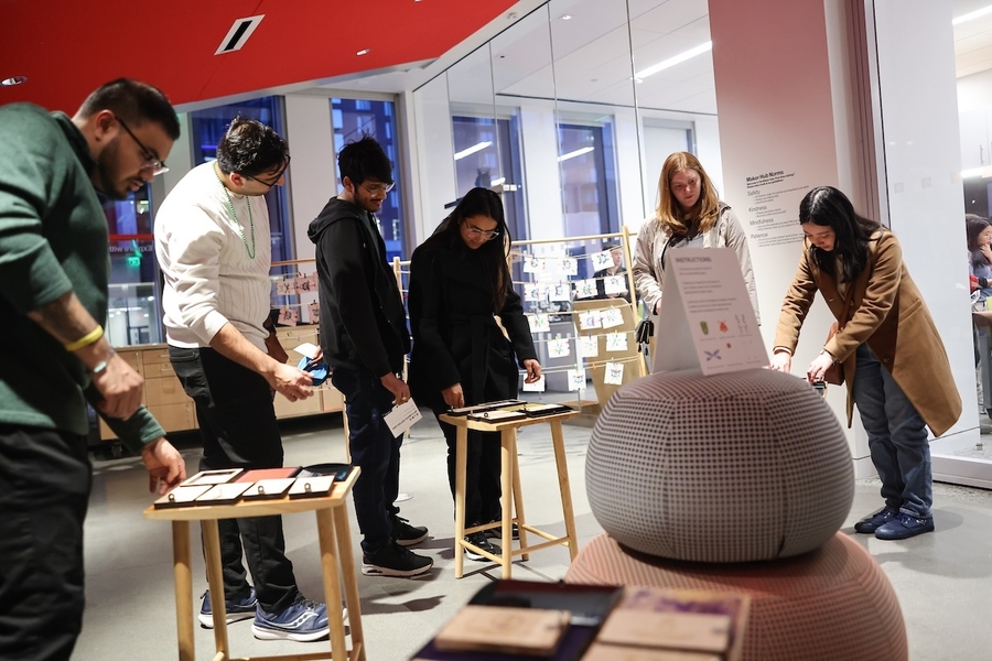Museum visitors look at displays on small tables