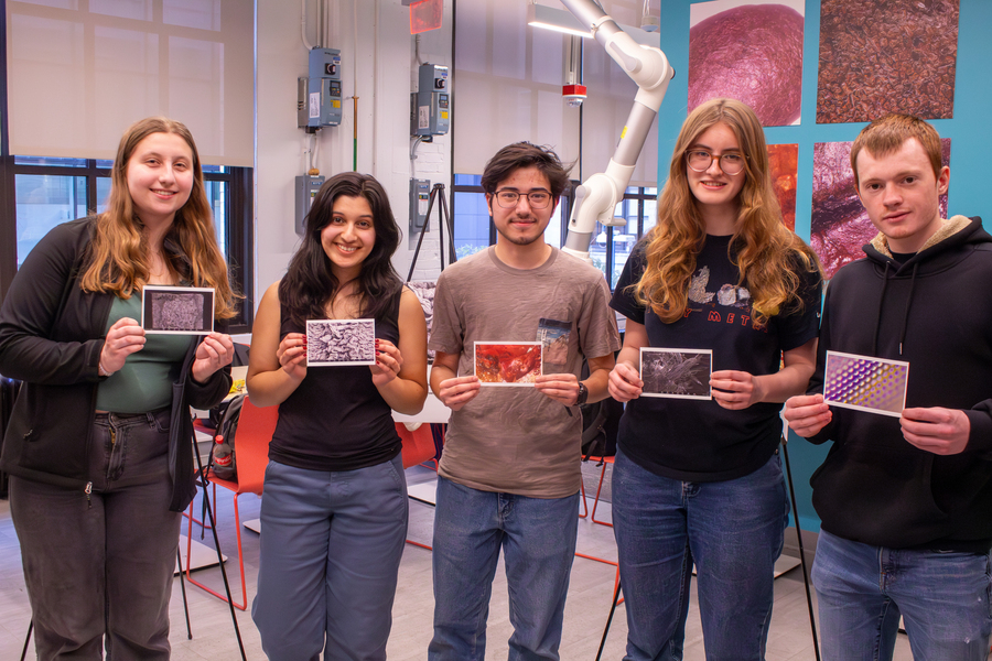 Five MIT students pose holding postcards of their award-winning images.