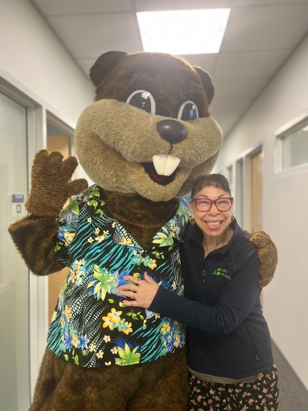 Juanita Battle hugs Tim the Beaver in a hallway