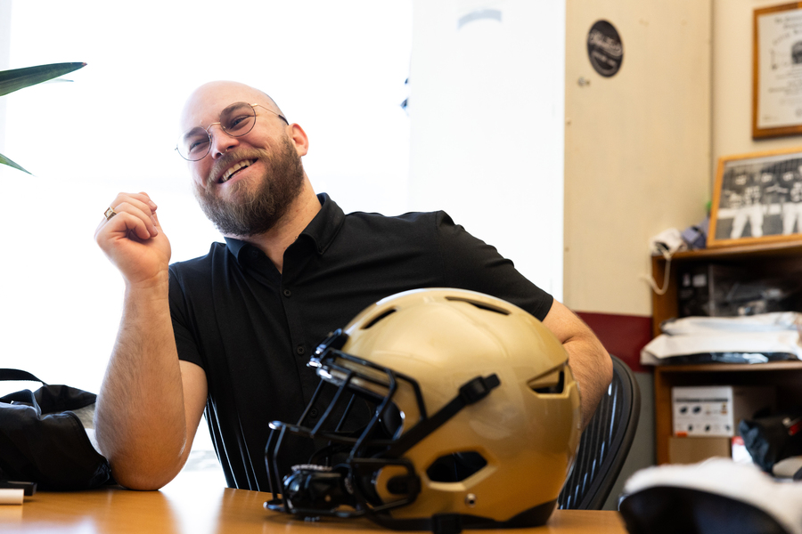 Kodiak Brush sits at desk with football helmet