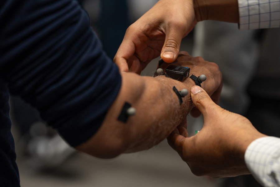 Sensors affixed to an arm being held by another person's hands