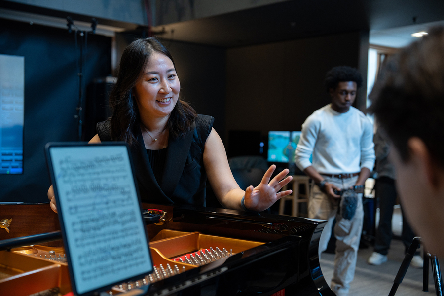 Mi-Eun Kim, leaning on an electronic piano, speaks to a pianist who is out-of-frame