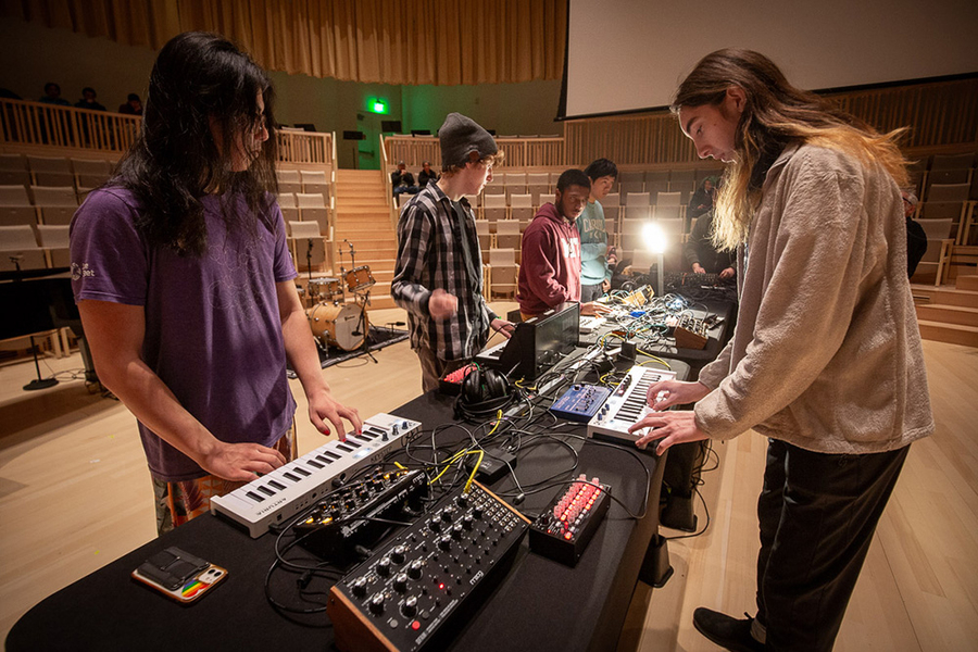 Members of the MIT Laptop Ensemble demonstrate electronic instruments in a music room