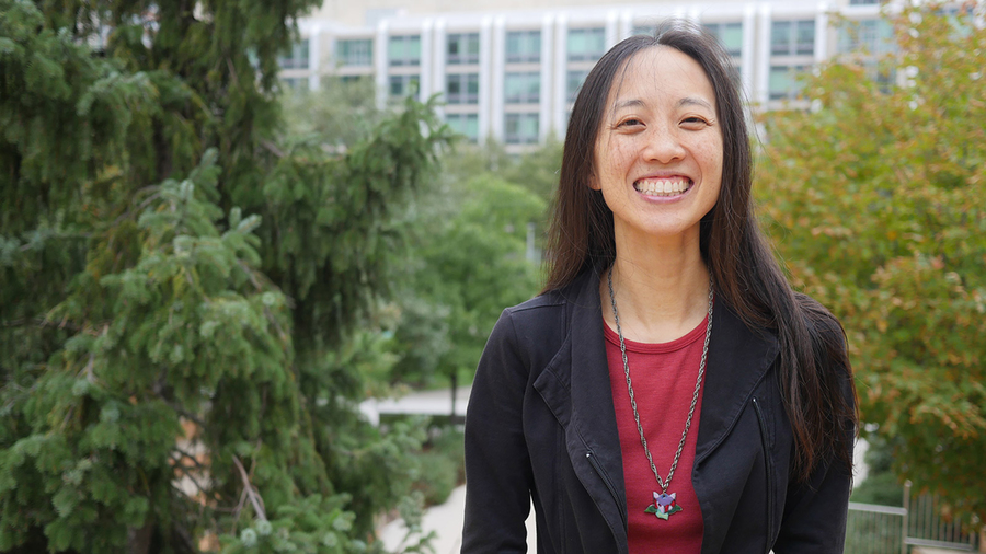 Vanessa Cheung poses outside with trees and a lab building in the background