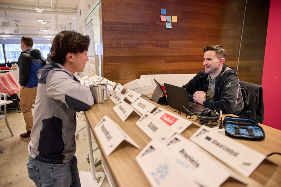 David Brown sits at a large desk in the Trust Center. He is talking to another person on the other side of the desk.