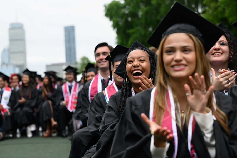 Seated graduates clapping and smiling