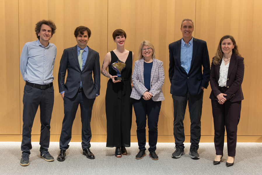 Essay winner Annaliese Meyer (middle, holding trophy) stands with MIT officials