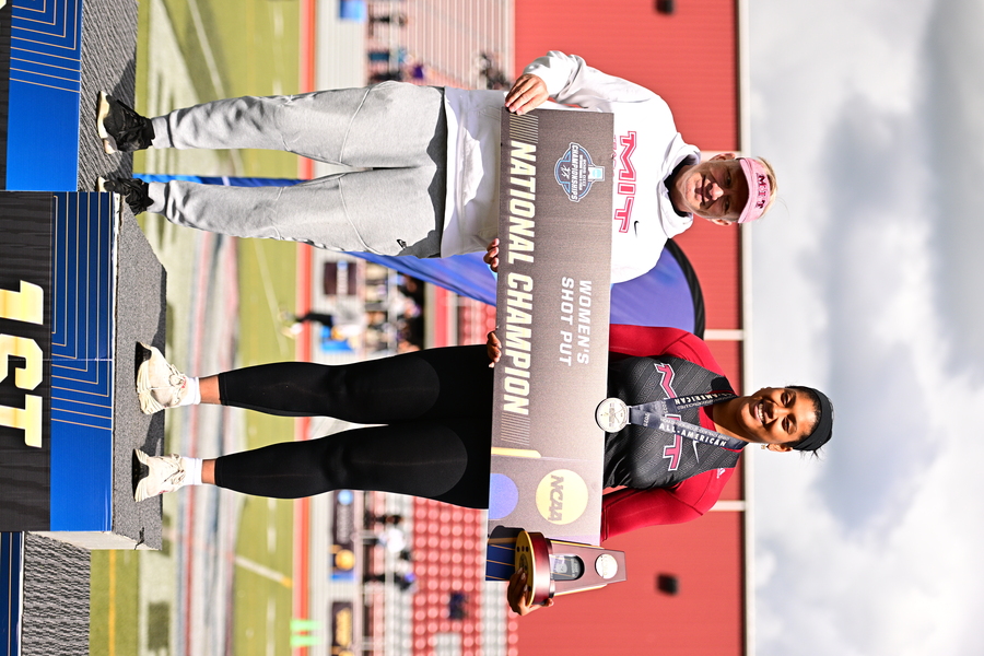 Alexis Boykin and her coach on the podium, holding a championship banner and trophy