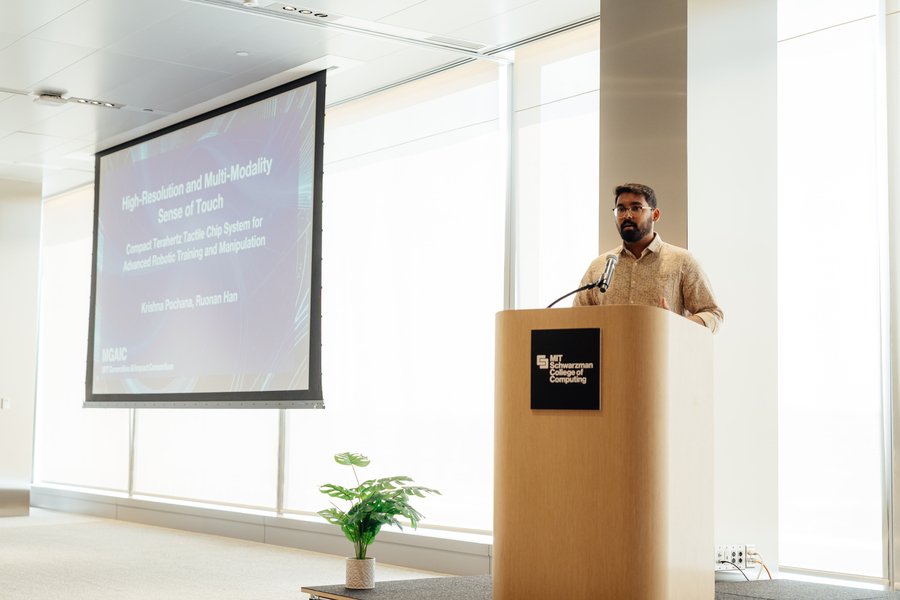A man in glasses and a khaki button-down shirt stands behind a lectern. Behind him is a slide that reads " J1137	High-Resolution and Multi-Modality Sense of Touch: Compact Terahertz Tactile Chip System for Advanced Robotic Training and Manipulation."