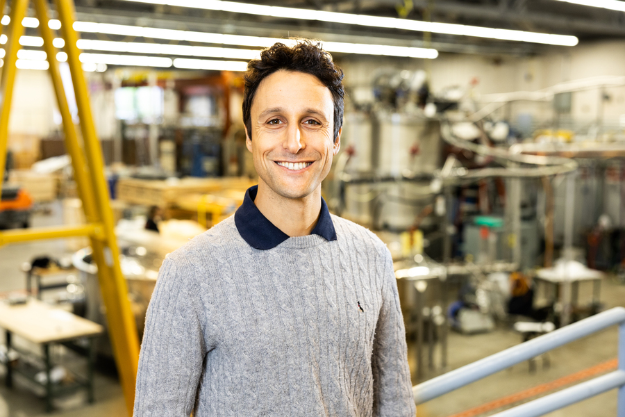 David Cohen-Tanugi stands in front of equipment in a lab at MIT