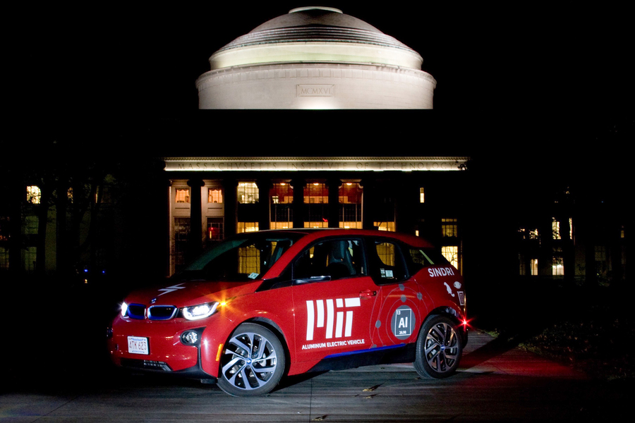 An aluminum electric vehicle in front of MIT’s Great Dome