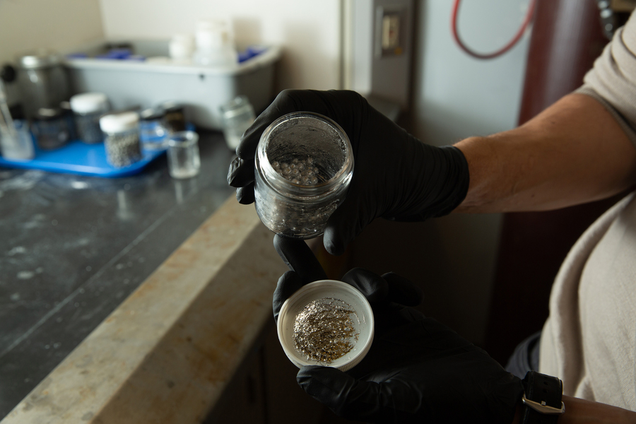 An open jar of aluminum pellets.