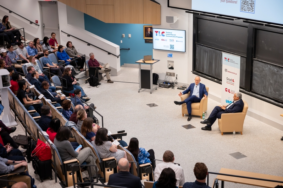 Balcony view of L. Rafael Reif and Anantha Chandrakasan sitting in easy chairs in front of an auditorium