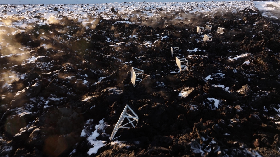 Isometric view of eight triangular tubular metal objects in a rocky landscape.
