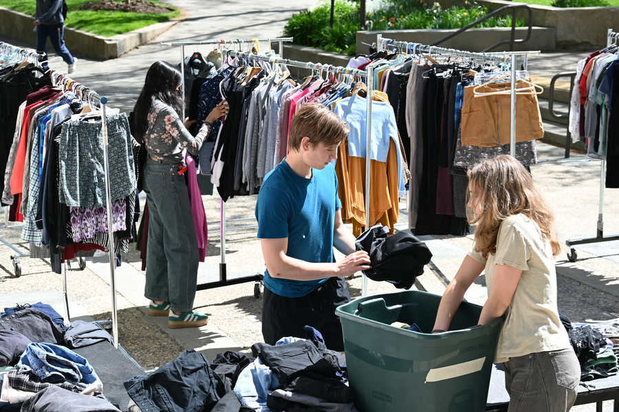 Cameron Dougal works amidst racks of clothing at an outdoor popup sale