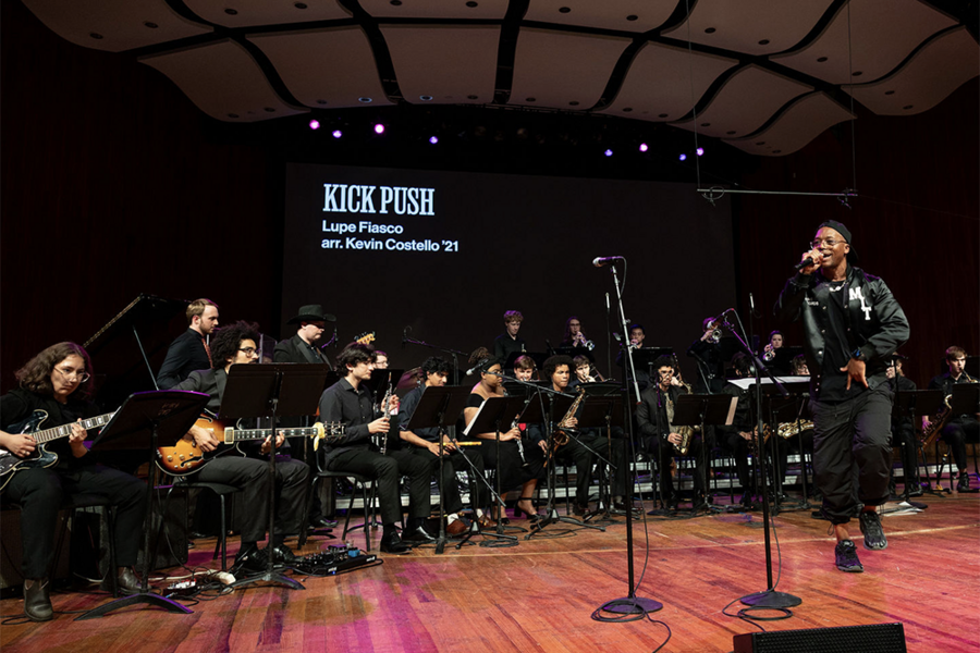 Lupe Fiasco performs with the MIT Festival Jazz Ensemble on an indoor stage