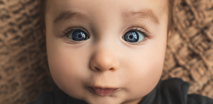 Photo of a baby's face with big blue eyes that don't quite seem perfectly focused yet