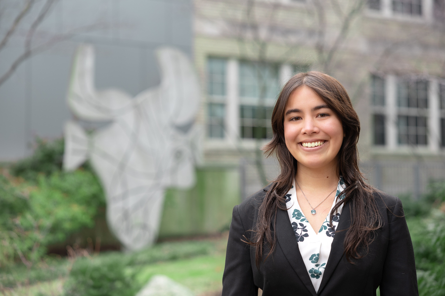 Photo of Haley Nakamura standing in front of a sculpture that looks like a bull's head