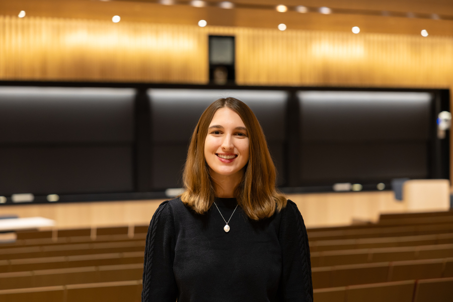 Hope Dargan sits in a brightly lit classroom at MIT, a blank chalkboard behind her.