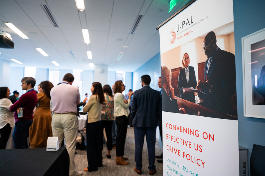 At right, a poster of the Convening on Effective US Crime Policy, with about 15 people mingling in the back of the room.