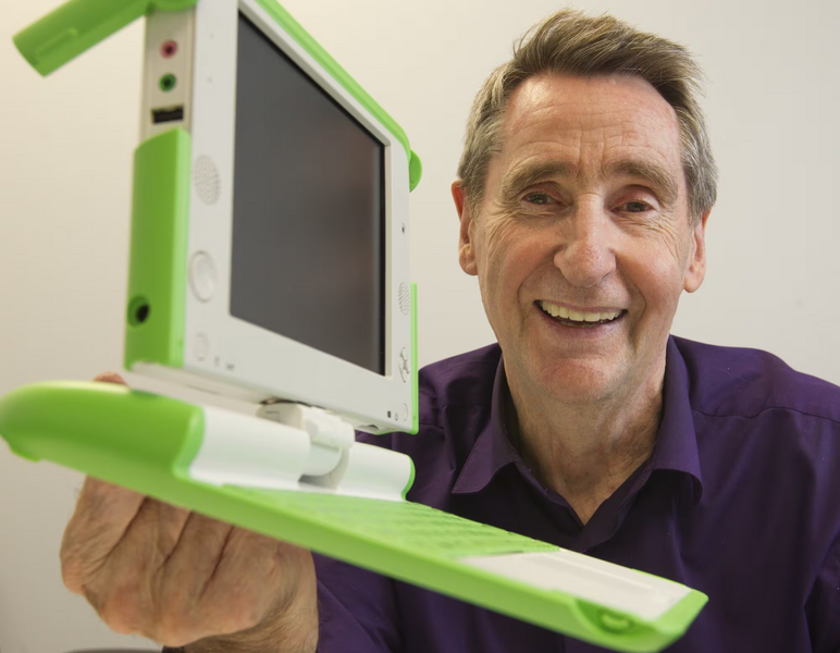 Barry Vercoe holding a chunky laptop computer in a lime-green plastic housing