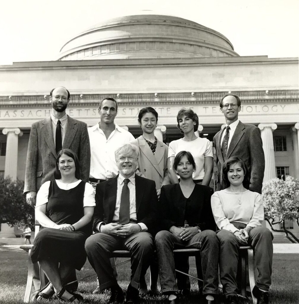 Nine people pose for a grayscale photo in front of the MIT Great Dome