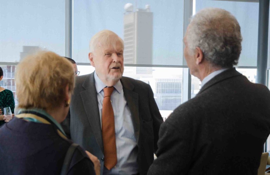 Three people speaking in a conference room at MIT