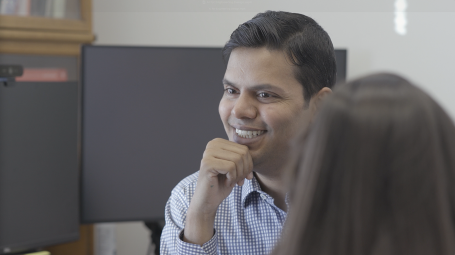 Faez Ahmed is seated  with his hand resting on his chin, looking off screen.