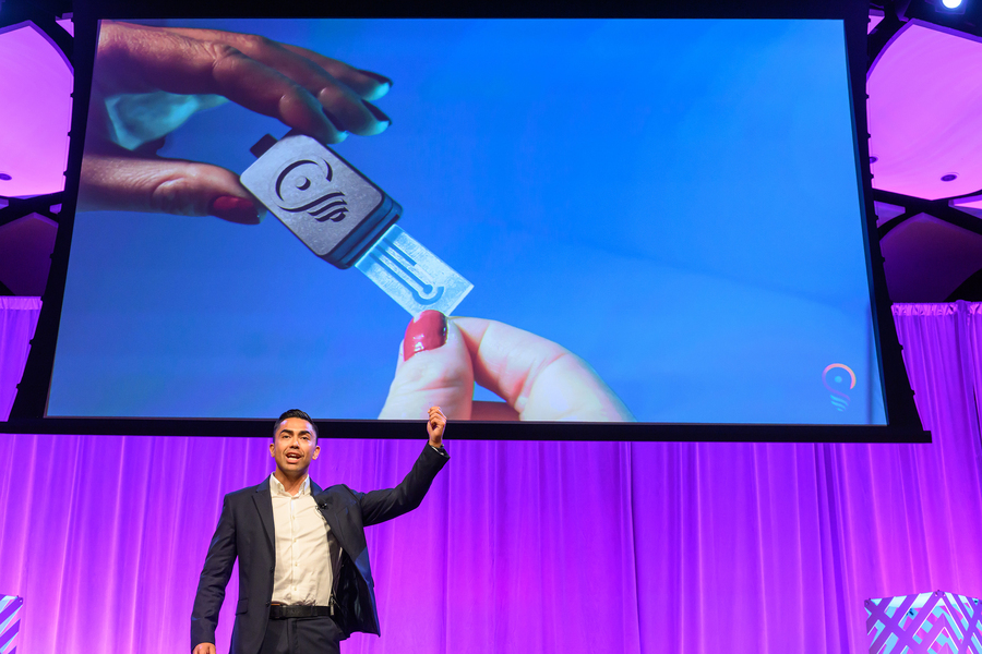 A male student presenting on a stage