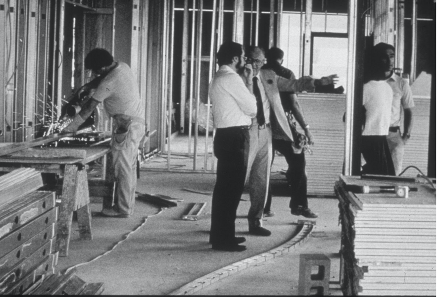Greyscale photo of David Baltimore and Jack Whitehead in an under-construction area of the Whitehead Institute.