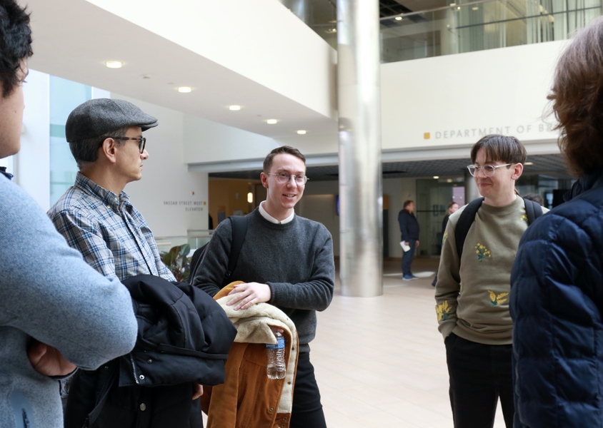 Matthias Michel speaks with a few people in an atrium lobby